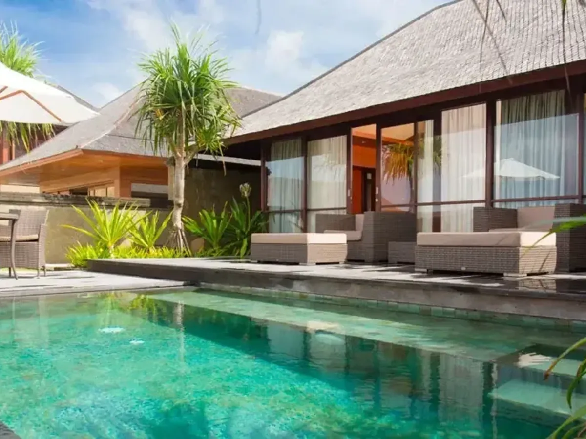 A villa lawn, pool and sun loungers