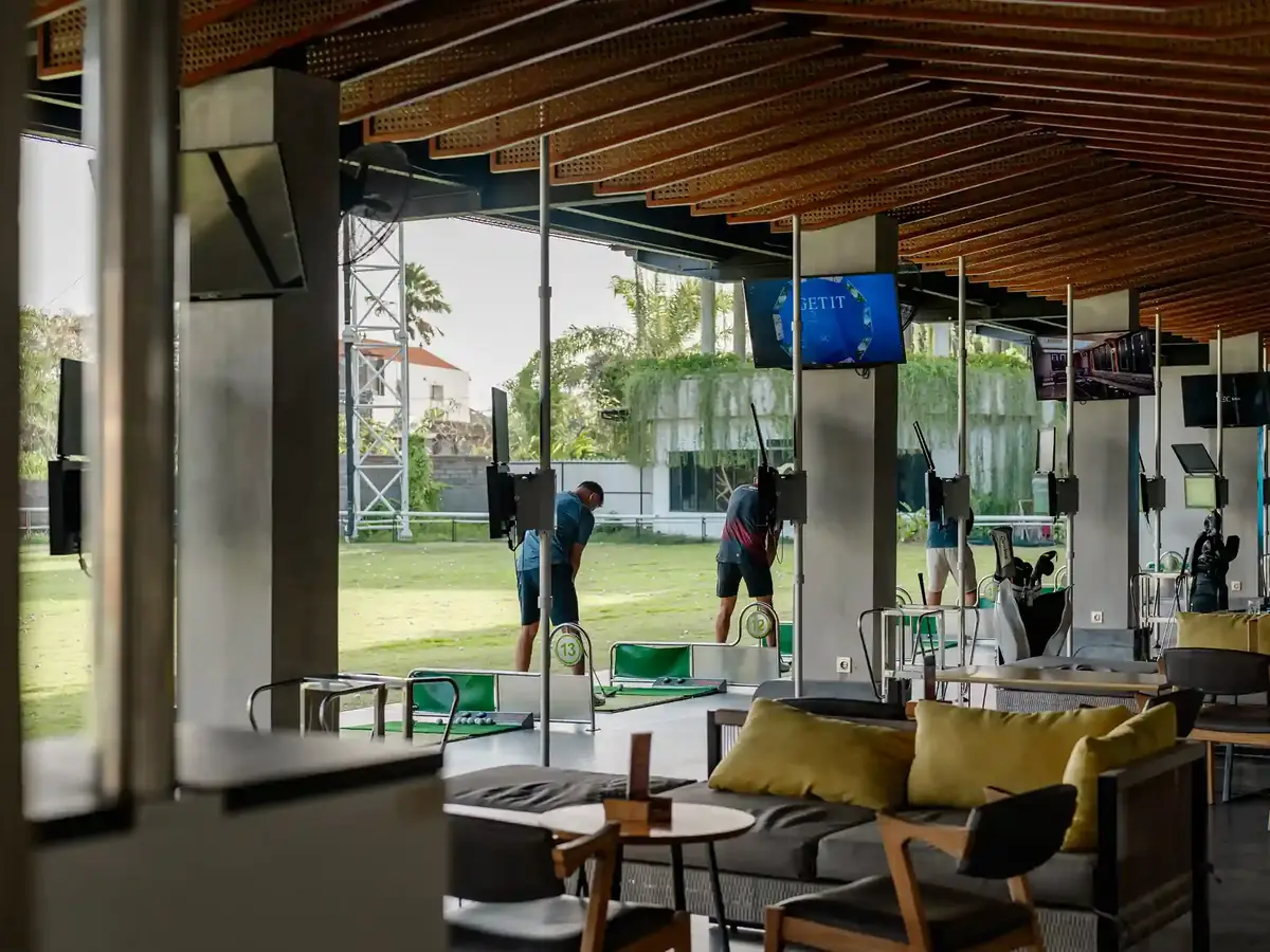 An open-air lounge beside a golf practice range