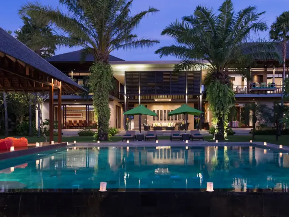 A Bali villa and its lagoon pool lit at dusk